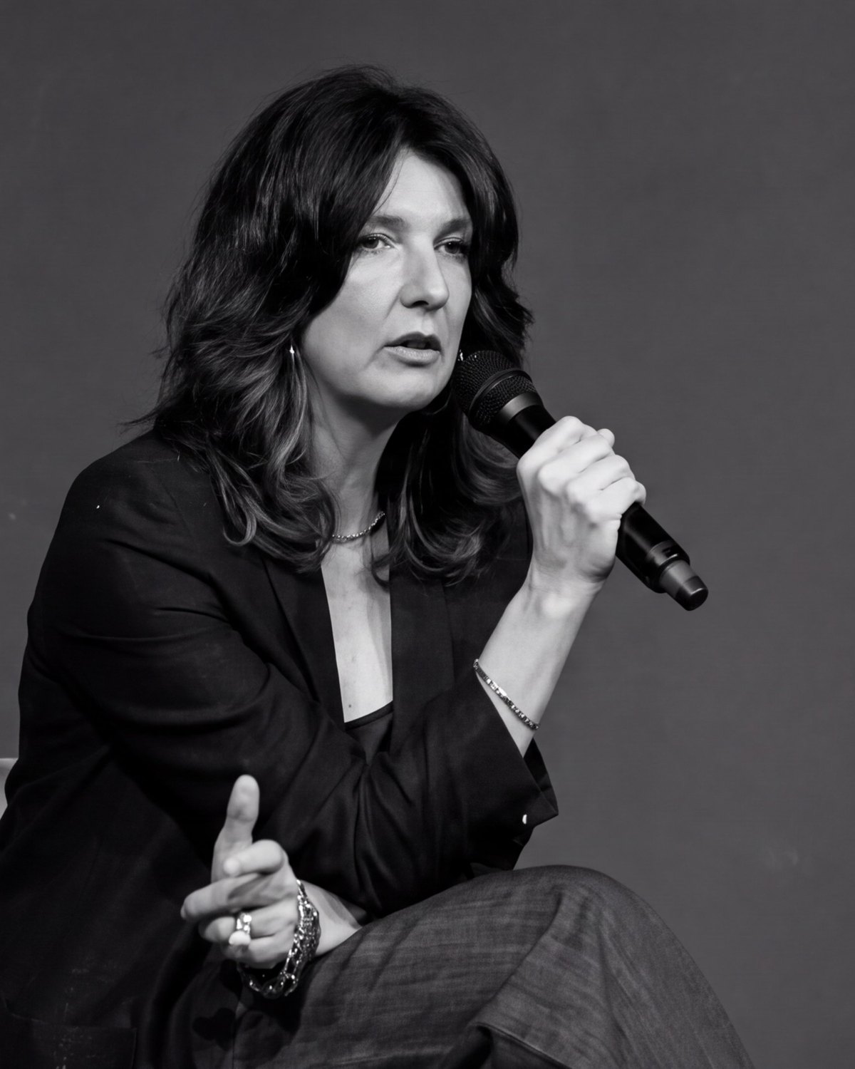 Viviana Santanello parla al microfono durante un talk, seduta, in bianco e nero